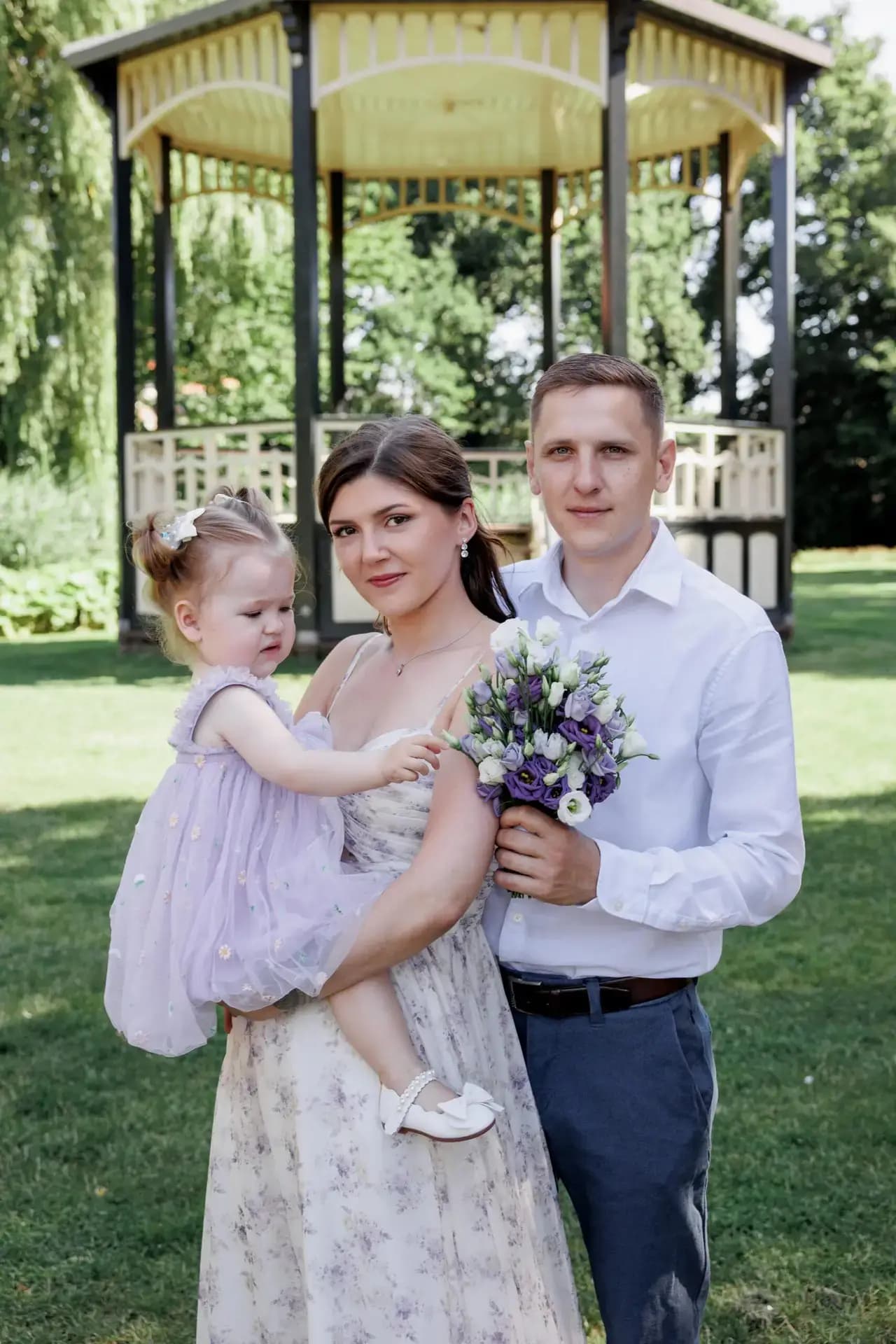Groen licht, open gazons en een familie spelend onder de bomen.